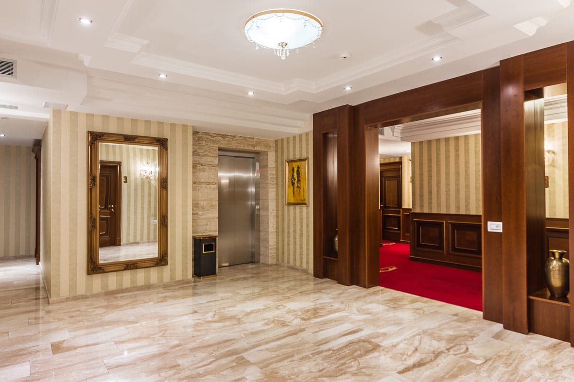 The elevator lobby with marble floor and gilt mirror
