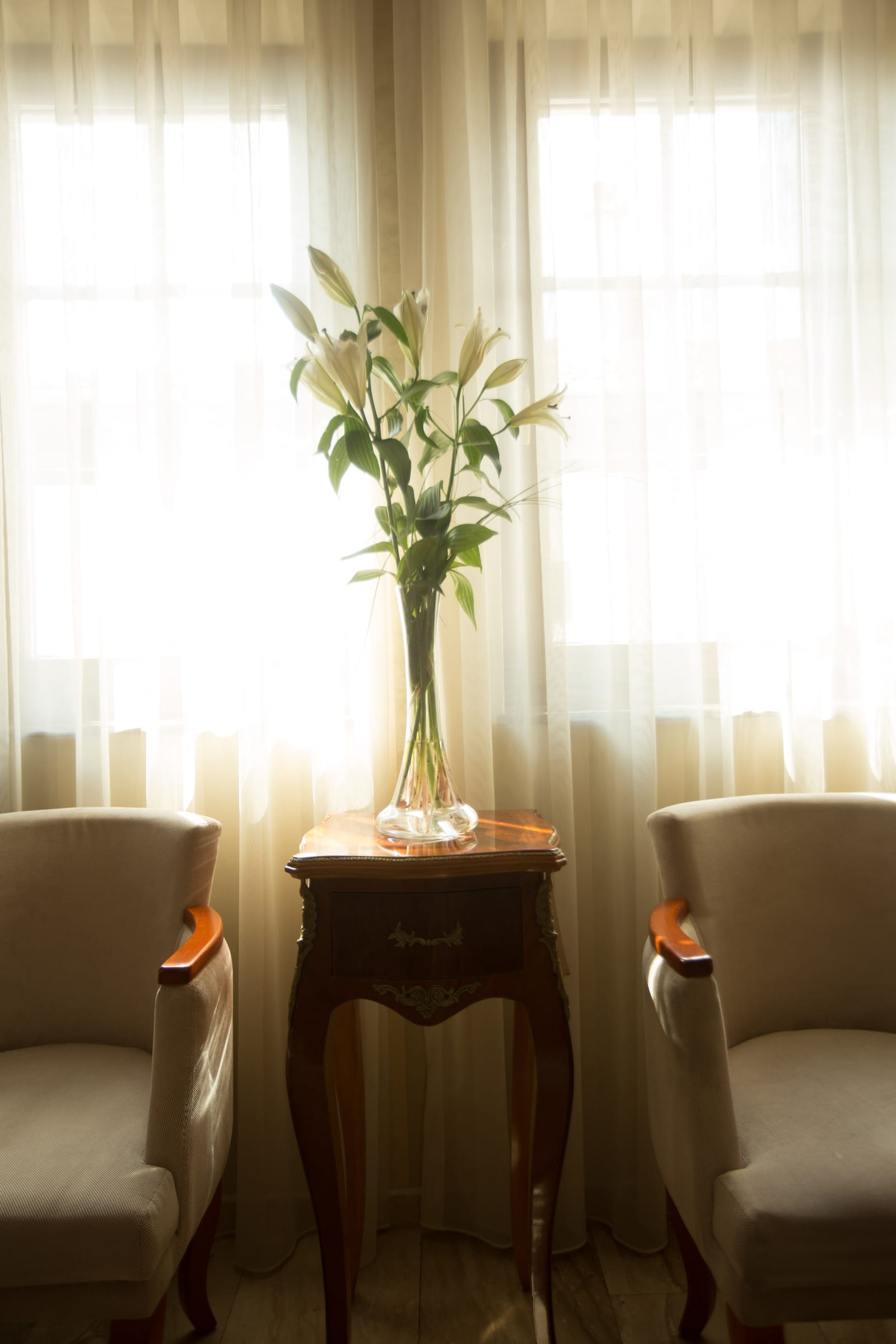 A quiet reading corner with lilies and cream armchairs