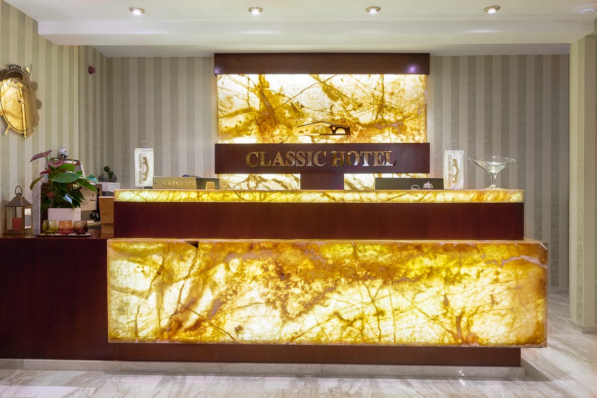 The glowing golden-onyx reception desk of Classic Hotel