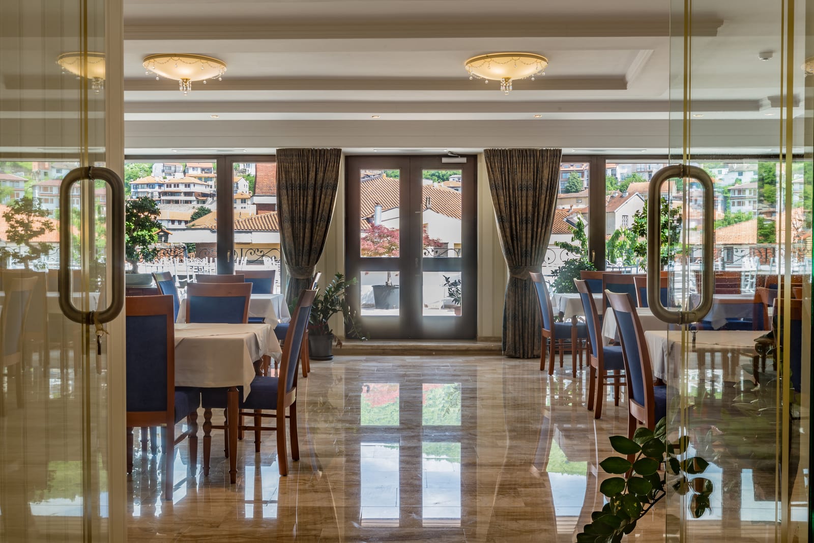 Looking through glass doors into the breakfast room and its windows onto the old town