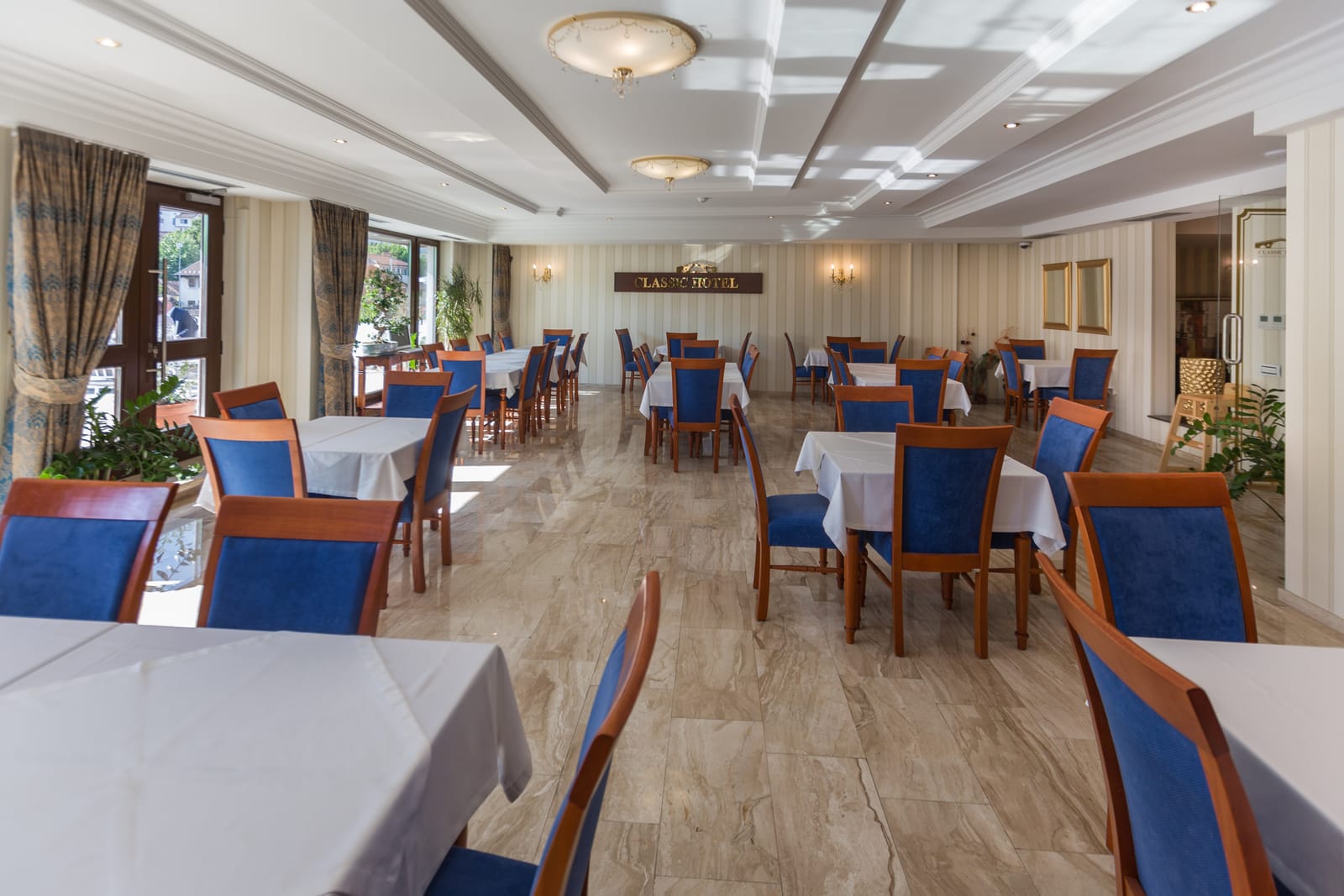 The breakfast room with marble floors and tall windows