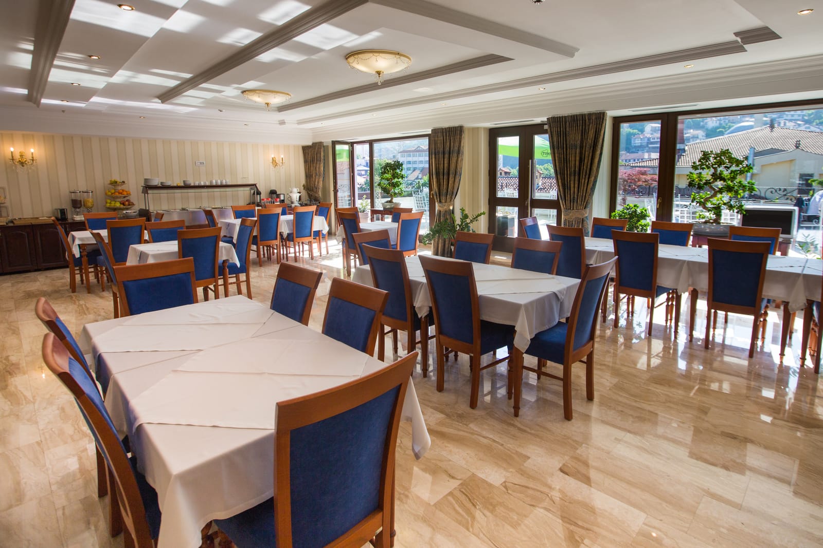 The bright breakfast room with blue velvet chairs and white linen