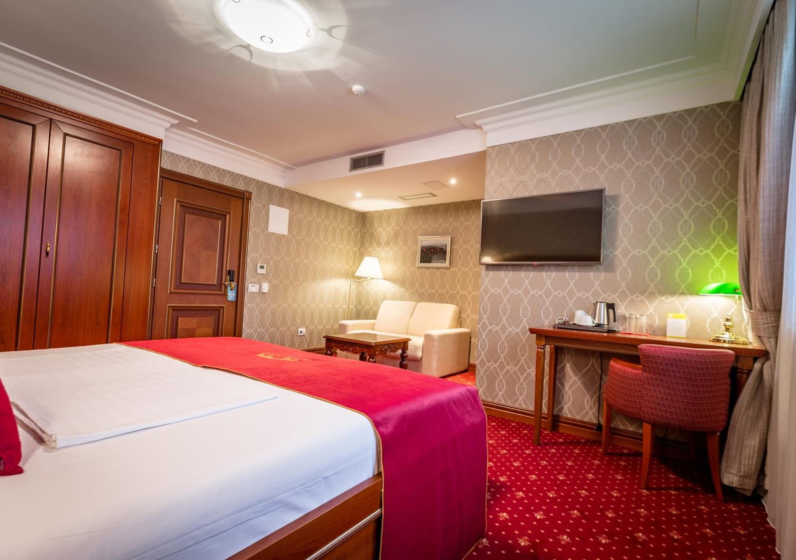 Junior Suite with a sofa, writing desk and flat-screen TV