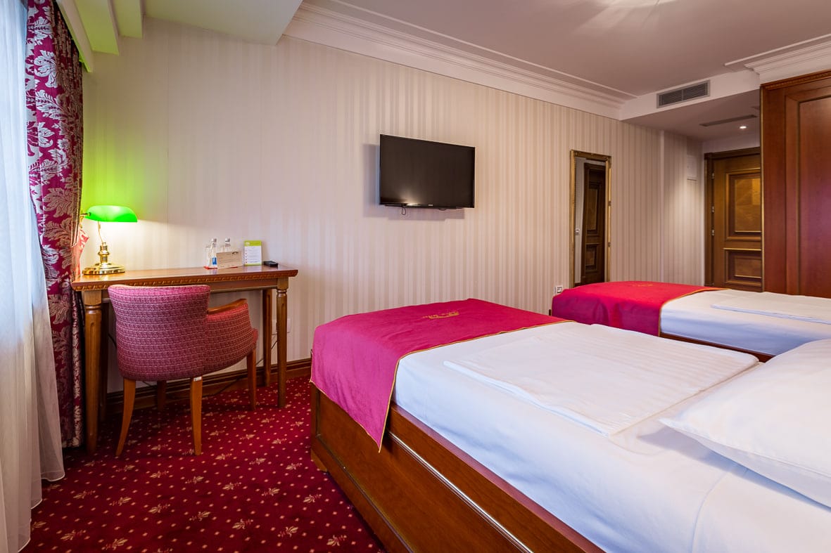 Deluxe Twin room with a desk, green banker’s lamp and flat-screen TV
