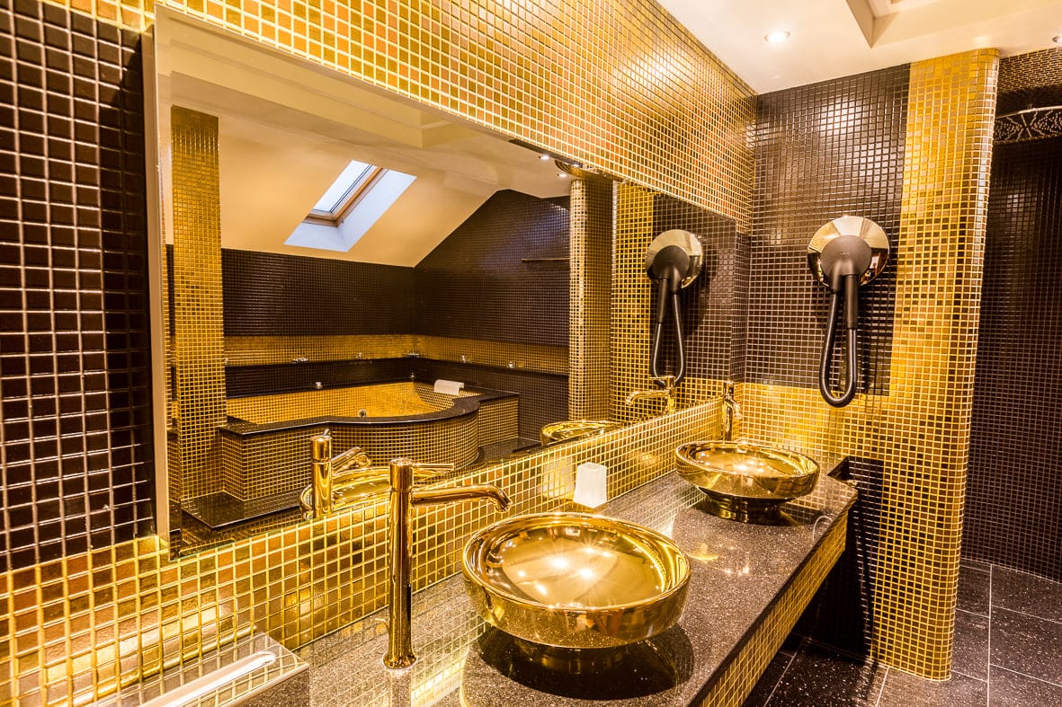 Suite bathroom with jacuzzi tub and gold basins