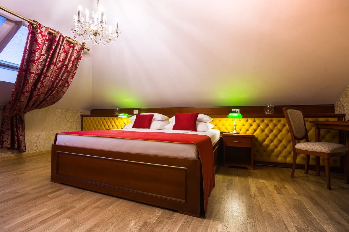 Attic suite bedroom with damask curtains and banker’s lamps