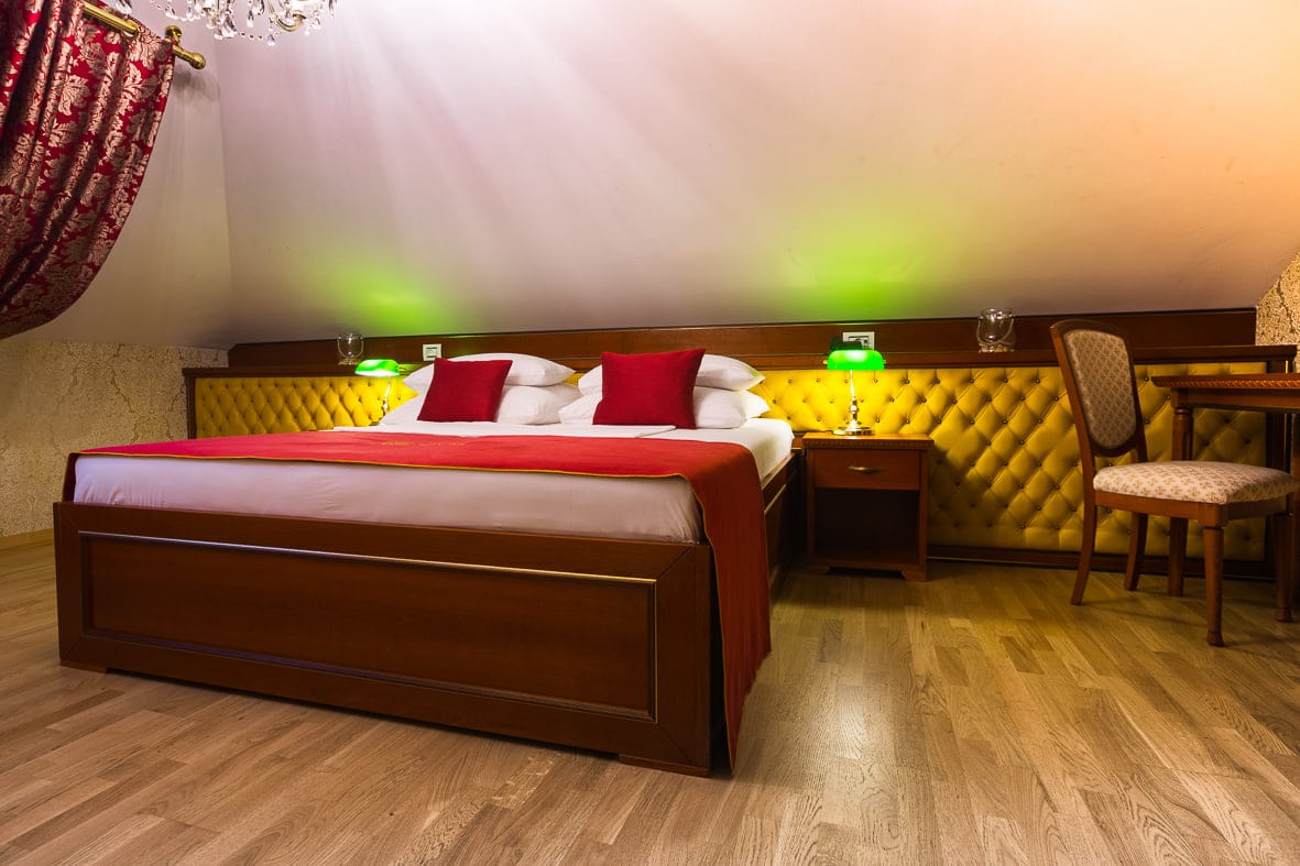Suite bedroom with golden headboard wall and writing desk
