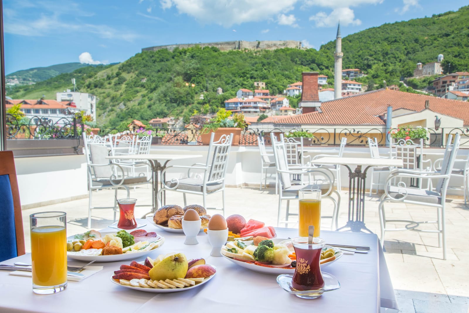Breakfast served on the sunny rooftop terrace beneath the fortress hill